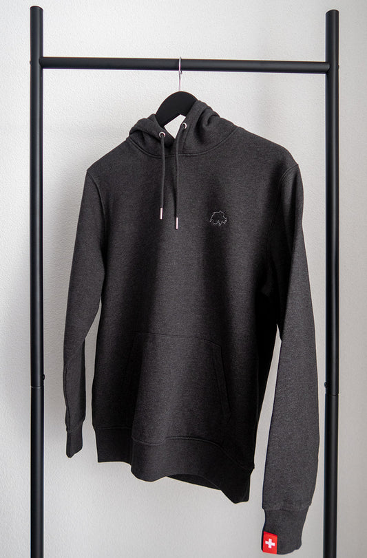 Dunkelgrauer unisex Twelvetia Pullover mit weiss gestickter Schweizer Landesumrandung auf linker Brust und Schweizer-Flagge-Etikett am linken Ärmel. Hängend an schwarzem Bügel vor weisser Wand.